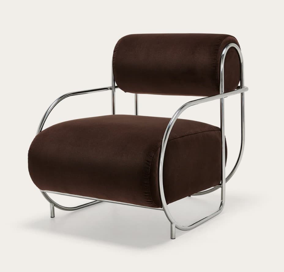 A modern armchair featuring a curved tubular metal frame with a polished chrome finish. The seat, backrest, and armrests are upholstered in a dark brown, velvet-like fabric, presenting a soft, inviting texture. The design is characterized by its minimalist yet distinctive silhouette, with the metal frame forming a continuous loop that supports the upholstered elements. — 3D model