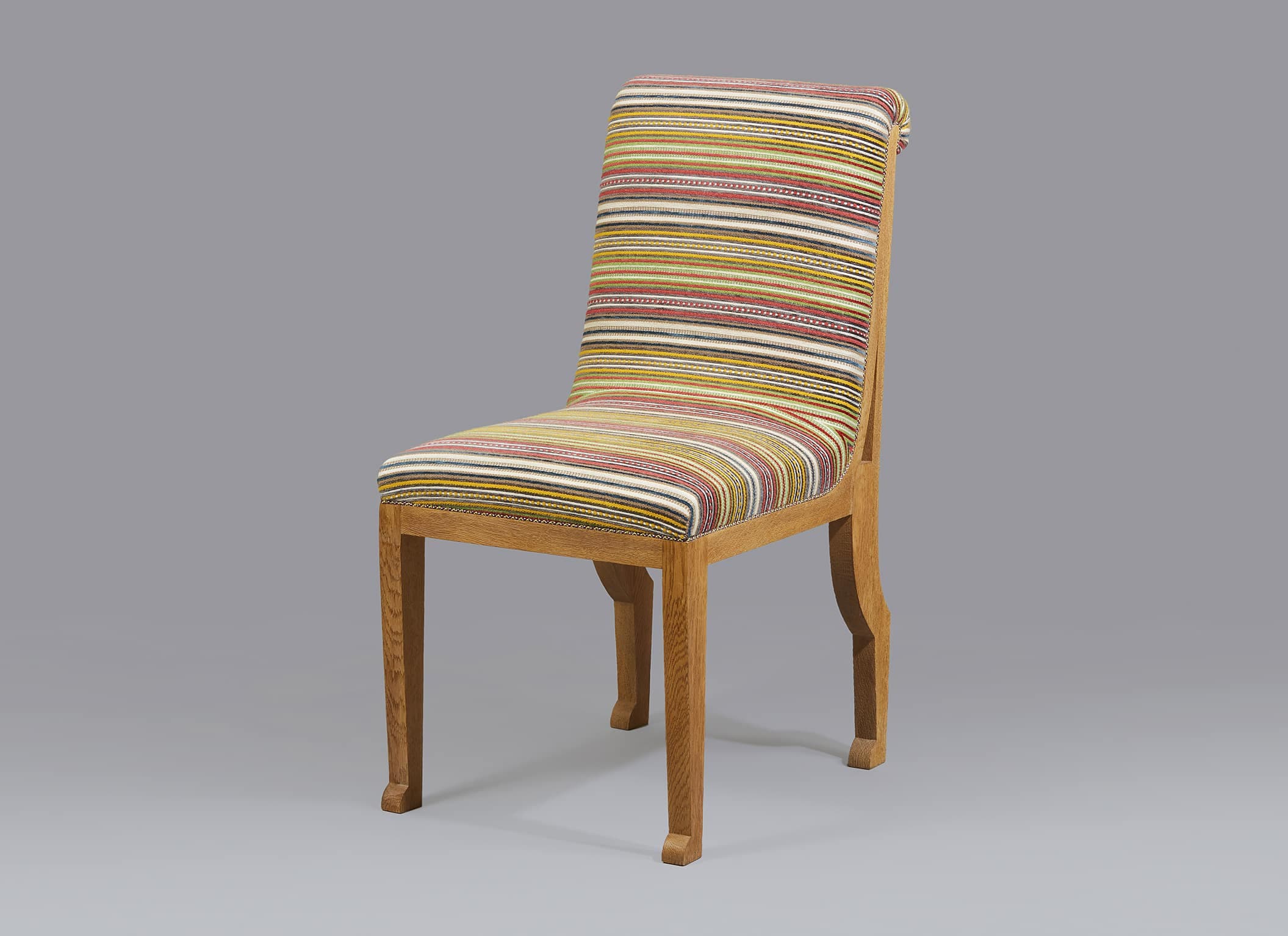 A wooden dining chair with upholstered seat and back. The upholstery features a striped pattern in various colors including yellow, red, white, and black. The chair has a curved backrest and straight legs. The frame is made of light-colored wood. — 3D model