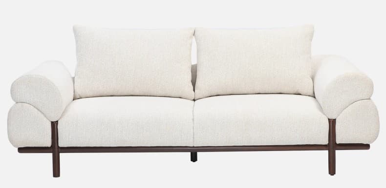 A contemporary two-seater sofa featuring a low-profile exposed dark wooden frame. The upholstery is a textured, light cream or off-white boucle-like fabric, covering the seat cushion, two loose back cushions, and distinctively rounded, padded armrests that appear to 'hug' the frame. The sofa has a clean, minimalist aesthetic with an emphasis on soft forms and contrasting materials. — 3D model
