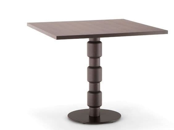 A square-top table with a single, decorative pedestal base. The pedestal features a stacked, cylindrical design with recessed grooves, leading down to a circular base. — 3D model