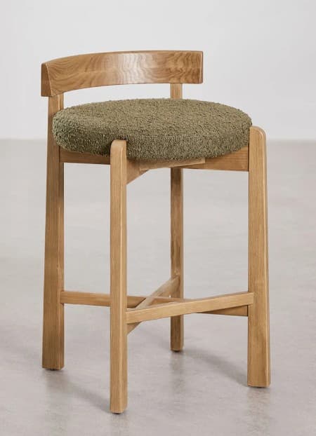 A wooden bar stool with a curved backrest and a rounded, upholstered seat. The stool features four legs connected by a cross brace for stability. The wood appears to be light-colored with a visible grain. — 3D model