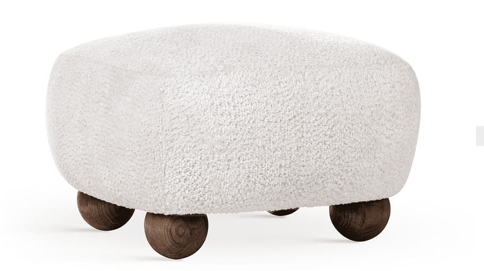A contemporary ottoman with a rounded, cushion-like top upholstered in a textured, cream-colored boucle fabric. It is supported by four spherical wooden legs with a visible grain pattern and a dark, natural wood finish. — 3D model