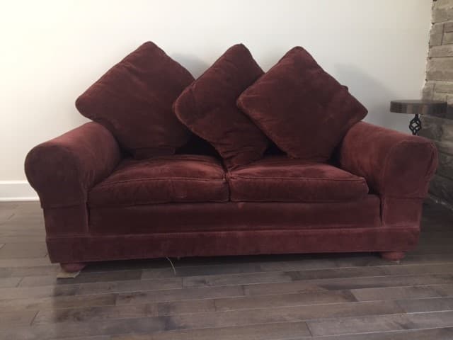 A two-seater sofa with plush cushions. The sofa has a rounded armrest on the left side and appears to be upholstered in a velvety fabric. Three square back cushions are arranged behind the seating area. — 3D model