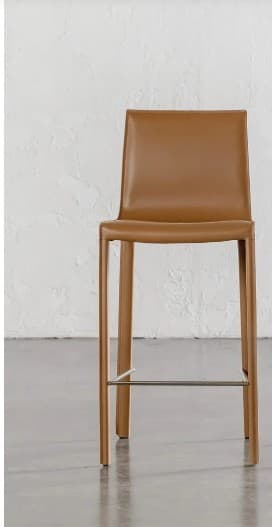 A minimalist modern bar stool featuring a sleek, integrated seat and backrest upholstered in tan leather. The entire frame, including the legs, appears to be wrapped in matching leather. A single, slender metal footrest is positioned between the front legs, providing both support and a subtle contrast. — 3D model