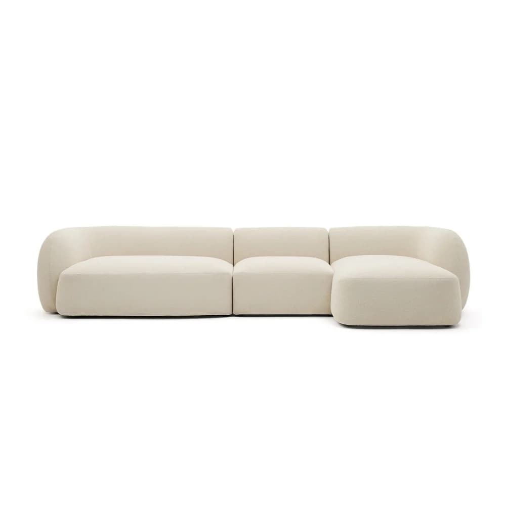 A contemporary modular sectional sofa, upholstered in a cream-colored boucle fabric. It features a low profile and rounded, curvilinear forms throughout its structure. The sofa is composed of three distinct sections: two armless mid-sections and one end section with an integrated chaise lounge and a rounded armrest/back. The design emphasizes comfort and a soft, organic aesthetic. — 3D model