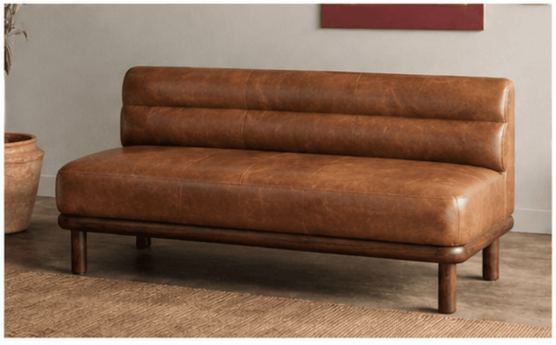A compact, two-seater sofa with a low backrest and a wooden base. The upholstery appears to be distressed brown leather, featuring horizontal channel tufting on the backrest. The base consists of a dark wood frame with four cylindrical legs. — 3D model
