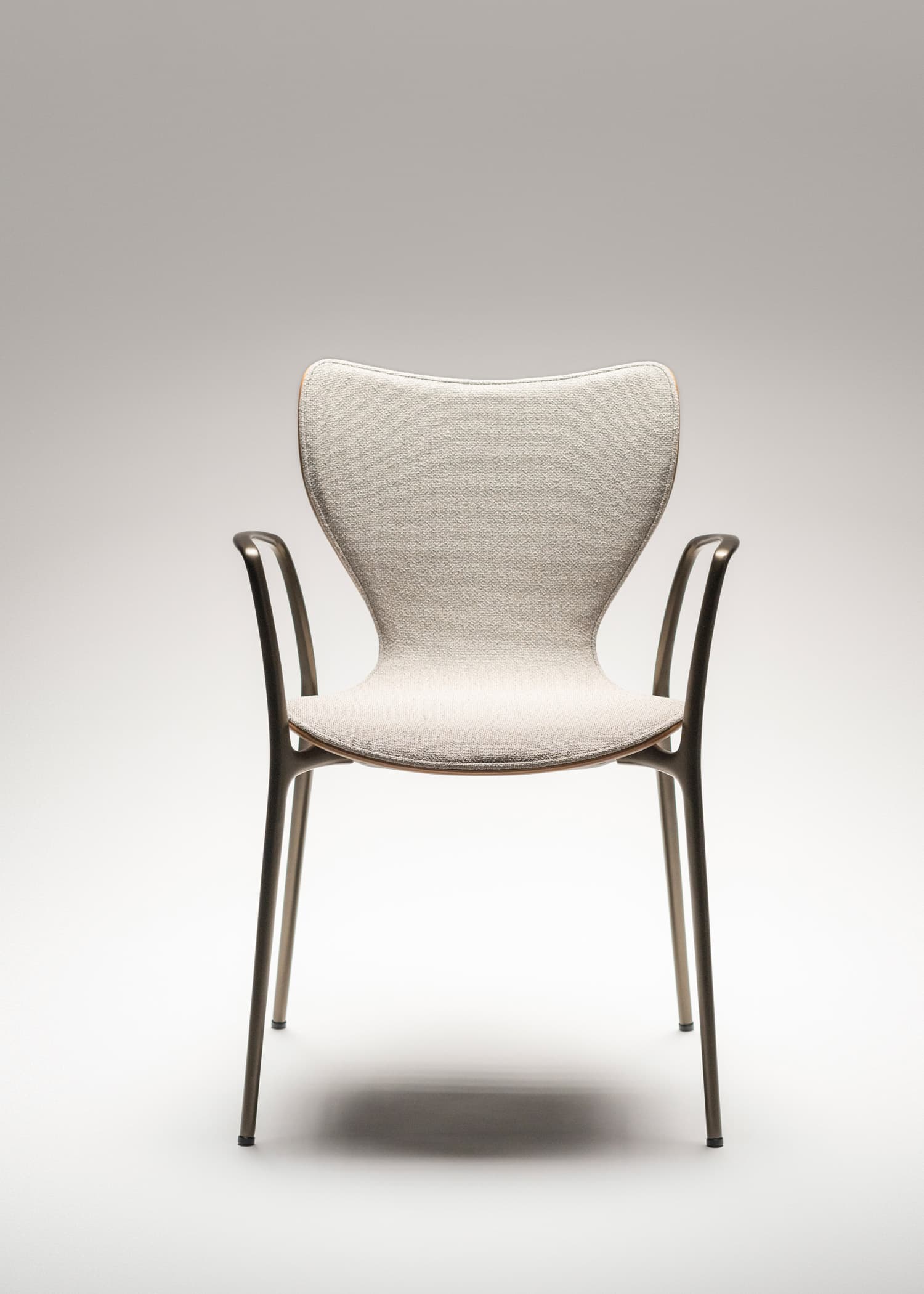 A modern armchair with a distinct, contoured backrest and a upholstered seat. The frame and legs are thin and appear to be made of metal, providing a sleek and minimalist aesthetic. The upholstery is a textured, light-colored fabric. — 3D model