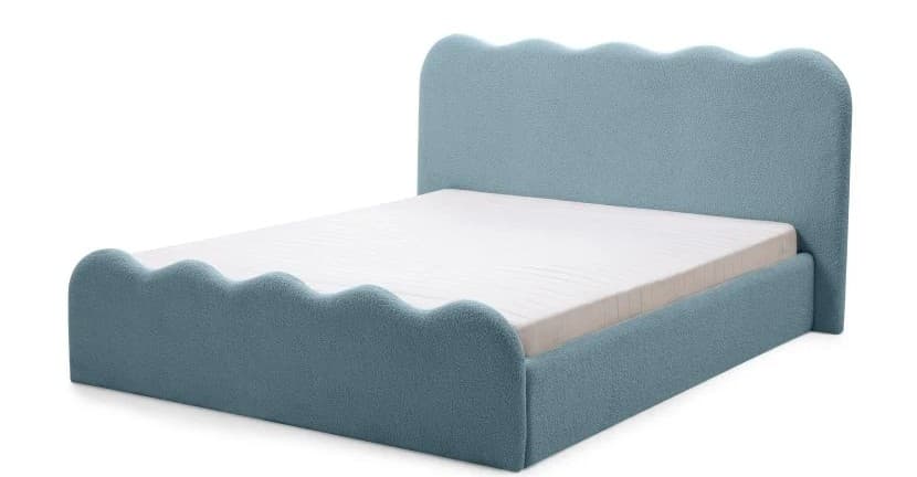 A bed frame upholstered in a textured, light blue fabric. The headboard and the footboard have a distinctive scalloped or wave-like edge design. A white mattress is placed on the bed frame. — 3D model