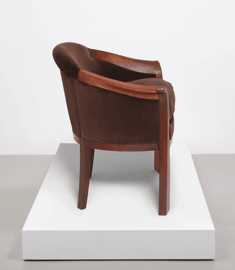 A dark brown upholstered armchair with a distinct Art Deco design, featuring a curved back, exposed wooden armrests, and tapered wooden legs. The fabric appears plush, likely velvet or a similar textile. — 3D model