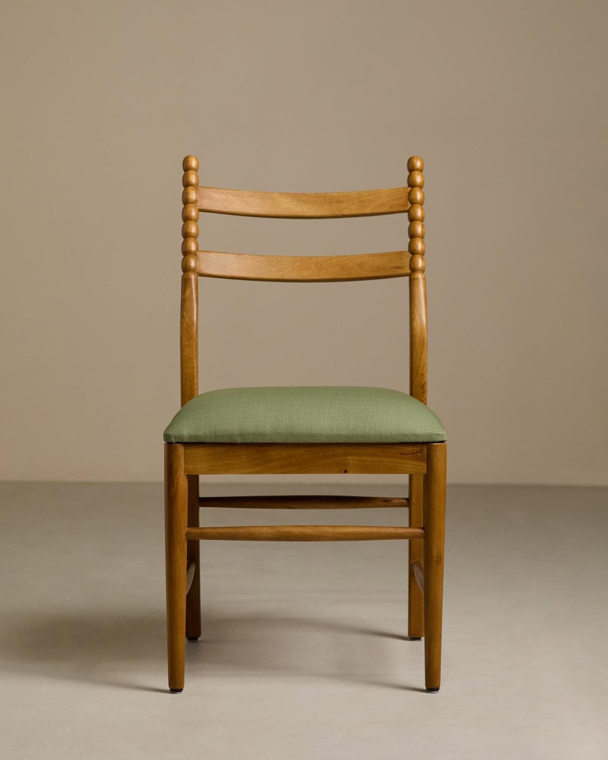 A light-toned wooden dining chair featuring a distinctive bobbin-turned back structure, horizontal curved slats, and a vibrant green upholstered seat. — 3D model