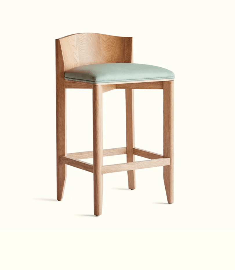 A wooden bar stool with a light wood finish. It features a gently curved backrest and a cushioned seat. The frame consists of four legs connected by crossbars for stability. — 3D model