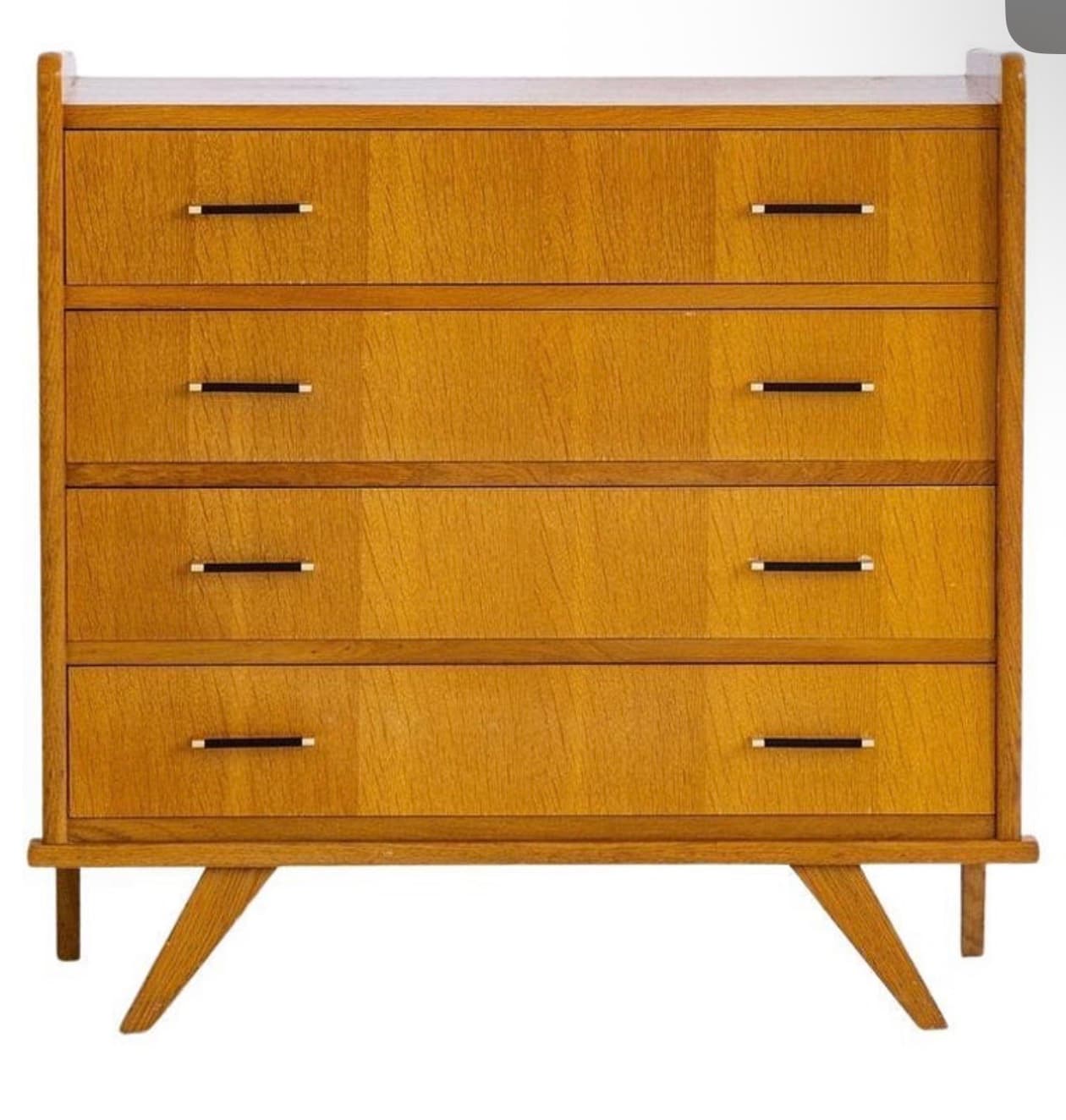 A vintage wooden dresser with four drawers. The dresser features a light wood grain finish, horizontal drawer fronts, and minimalist black and brass handles. It is supported by angled legs, characteristic of mid-century modern design. — 3D model
