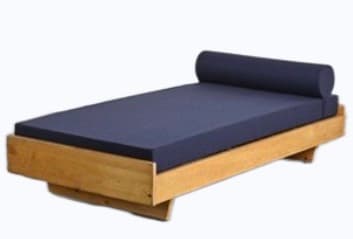 A minimalist daybed featuring a light-toned wooden frame and a dark blue mattress with a matching cylindrical bolster pillow. The low-profile design and natural wood finish suggest a modern or Scandinavian aesthetic. — 3D model