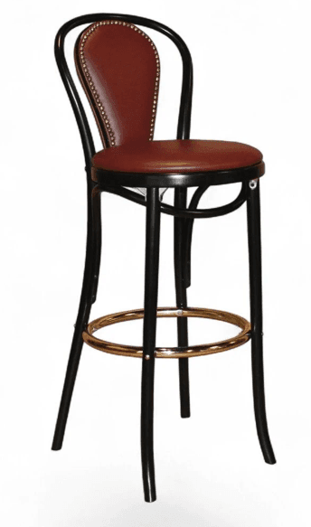 A tall bar stool with a curved backrest and a circular seat. The frame is made of dark-colored wood, possibly bentwood, with a rounded profile. The seat and backrest are upholstered in a deep red material, likely leather or vinyl, and are tufted or decorated with nailhead trim along the edges of the backrest. A circular metal footrest is integrated between the legs. — 3D model