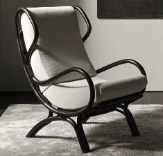 A contemporary lounge chair featuring a gracefully curved frame, likely crafted from bent rattan or wood, finished in a dark, almost black hue. The frame forms a continuous loop for the arms and back, with splayed legs providing stability. It is fitted with thick, light beige or off-white upholstered cushions for both the seat and back, providing a comfortable and inviting seating experience. — 3D model