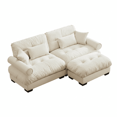 This image features a contemporary cream-colored modular sofa with a chaise component. The sofa is upholstered in a soft, plush fabric and features deep, tufted cushions on both the seat and backrests. It includes several throw pillows and cylindrical bolster pillows integrated into the armrests. The design is low-profile with dark, square feet, suggesting a focus on comfort and modern aesthetics. — 3D model (AI enhanced source)