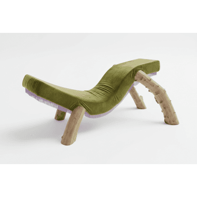 A chaise lounge with a distinctive organic design. The seating surface is upholstered in a plush, olive-green velvet fabric with subtle pleating. It is supported by two pairs of thick, natural wood logs that serve as legs, retaining their bark and irregular shapes. A band of light purple fringe runs along the underside edge of the upholstered seat. — 3D model (AI enhanced source)
