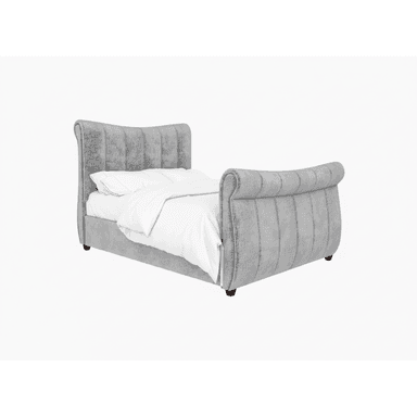 A contemporary upholstered sleigh bed frame featuring a gracefully curved headboard and footboard, both adorned with vertical channel tufting. The entire frame is covered in a soft, grey textured fabric, likely velvet or a similar material. The bed is designed with a low profile, supported by short, dark wooden legs. A white duvet and pillows are visible on the mattress, indicating its function. — 3D model (AI enhanced source)