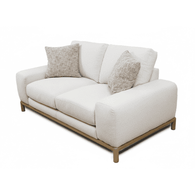 A modern, two-seater sofa featuring a plush, textured cream or off-white fabric upholstery. It has gently rounded track arms and a low back with two removable back cushions. The seating area consists of two separate seat cushions. The sofa is elevated by a minimalist wooden frame that forms the base and extends into four short, cylindrical wooden legs. Two smaller, patterned throw pillows are included. — 3D model (AI enhanced source)