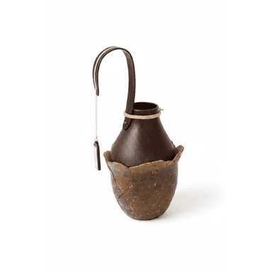 A unique dual-tone decorative vessel featuring an organic, textured outer shell in an earthy brown hue, cradling a smooth, dark brown inner vessel. A curved dark brown leather strap is attached to the inner vessel, accented with a small, rectangular tag. — 3D model (AI enhanced source)