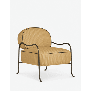 An upholstered armchair featuring a dark, curved metal frame with a distressed finish. The seat and back cushions are generously padded and rounded, upholstered in a light gold or tan fabric with a fine geometric pattern and outlined with dark piping. The frame includes elegantly curved armrests and four distinct legs with subtle scroll details at the base. — 3D model (AI enhanced source)