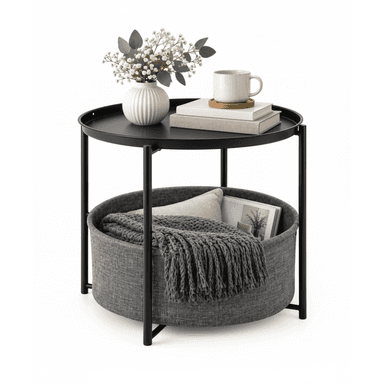 A modern round side table featuring a black metal frame and a black tray-style tabletop. Below the tabletop, a large, round, gray fabric basket is integrated into the frame, designed for storage. The table sits on four slender black metal legs. — 3D model (AI enhanced source)