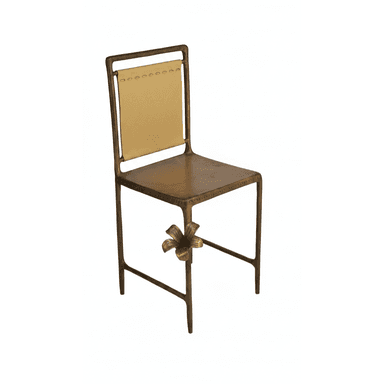 A decorative chair with a bronze-toned metal frame. The seat and backrest appear to be made of metal. The backrest features a panel of light tan leather or faux leather, attached with visible stitching. A prominent floral embellishment is attached to the front leg of the chair. The overall design suggests an artistic or decorative style. — 3D model (AI enhanced source)