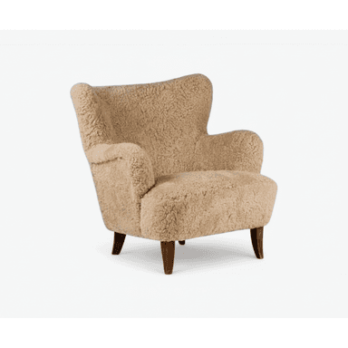 A light brown, sheepskin-upholstered armchair featuring a distinctive wingback silhouette and four dark wooden tapered legs. The chair presents a plush, textured surface that appears soft and inviting. Its design includes gently curved lines and rounded armrests, suggesting a comfortable and enveloping form, all in excellent condition. — 3D model (AI enhanced source)