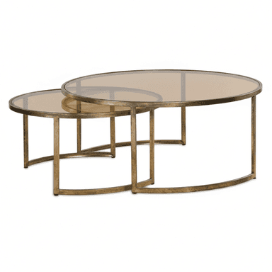 A set of two oval nesting coffee tables featuring amber-tinted glass tops and distressed gold-finished metal frames. The larger table is an elongated oval, and the smaller table is a slightly more compact oval, designed to partially slide under the larger one. The metal frames are slender with a brushed or aged appearance, forming a sturdy base for the glass tops. — 3D model (AI enhanced source)