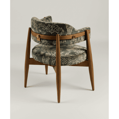 A barrel-back armchair featuring a dark-toned patterned upholstery and a visible wooden frame. The chair has a rounded back and integrated armrests, characteristic of a barrel design. Tapered wooden legs provide support, and a distinctive horizontal wooden band with brass hardware is visible on the upper back, securing the upholstery to the frame. — 3D model (AI enhanced source)