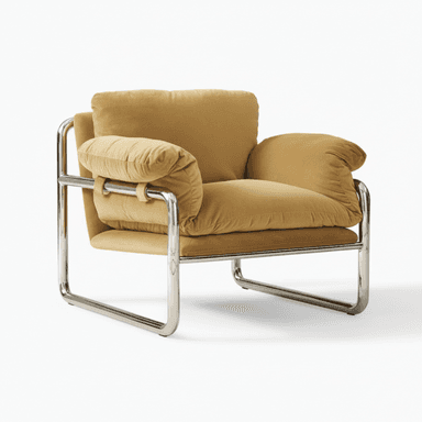 A modern armchair featuring a polished chrome tubular frame with large, plush, camel-colored fabric cushions. The frame forms a continuous loop for the base and back, with horizontal bars supporting the seat and providing structure for the armrests. The seat, back, and armrest cushions are soft and oversized, creating a comfortable, inviting appearance. The armrest cushions are secured to the frame with fabric straps. — 3D model (AI enhanced source)