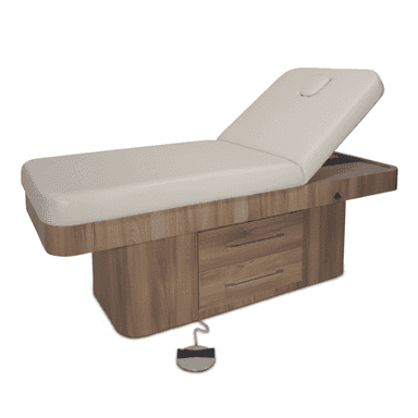 An electric spa treatment bed featuring a plush, light beige upholstered top with an adjustable backrest and an integrated face cradle. The robust base is constructed from light brown wood-grain laminate and includes two drawers with sleek silver-toned pull handles, providing convenient storage. A wired foot pedal is visible, indicating electronic height and recline adjustments. The design is modern and functional, suitable for professional environments. — 3D model (AI enhanced source)