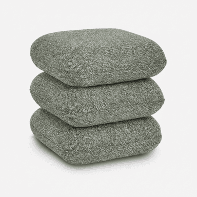 A stack of three square-shaped, soft cushions, upholstered in a speckled grey-green fabric. The cushions appear to be filled with a soft material, giving them a slightly rounded, plush appearance. They are neatly stacked on top of each other. — 3D model (AI enhanced source)