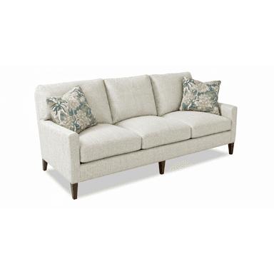 A contemporary three-seater sofa upholstered in a light, textured fabric, featuring clean lines and track arms. It includes three removable seat cushions and three removable back cushions, accompanied by two floral-patterned throw pillows. The sofa is supported by dark, tapered wooden legs. — 3D model (AI enhanced source)