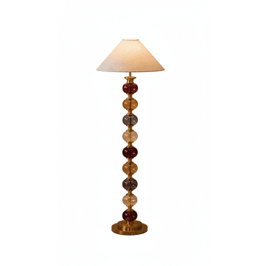 A tall, elegant floor lamp featuring a base constructed from a series of stacked, multi-colored translucent glass orbs separated by brass-toned metal rings, culminating in a simple, conical fabric shade. The orbs vary in color, including deep red, amber, and greyish hues, providing a striking visual appeal. The lamp rests on a sturdy, circular brass-toned metal base. — 3D model (AI enhanced source)