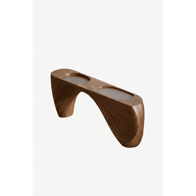 A long, low, sculptural coffee table crafted from what appears to be solid walnut wood. It features a continuous, curved form that acts as both top surface and support, creating a bridge-like structure. The top surface includes two distinct, circular recessed areas, likely intended for holding drinks or small objects. The wood exhibits a rich, dark brown tone with visible grain, and the design is characterized by smooth, organic lines. — 3D model (AI enhanced source)