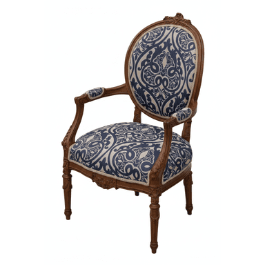 An ornate armchair featuring a carved wooden frame and upholstered in a blue and beige patterned fabric. The chair has an oval backrest, scroll-detailed arms, and cabriole legs. The wood frame exhibits intricate carvings, particularly on the crest rail, apron, and arm supports. — 3D model (AI enhanced source)