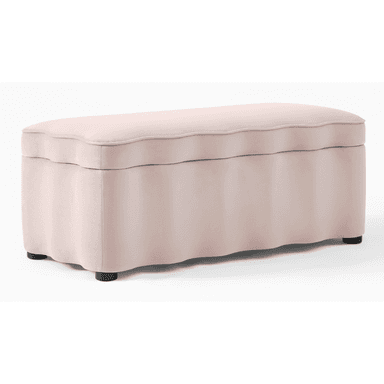 An oblong upholstered storage bench featuring a distinctive scalloped design on both its lift-off top cushion and along the base. The bench is covered in a soft, light pink fabric and rests on four discreet, low-profile black feet. Its top opens to reveal interior storage. — 3D model (AI enhanced source)