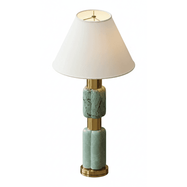 A contemporary table lamp featuring a stacked base of green marble and brass accents, topped with a white fabric conical shade. The base comprises two cylindrical green marble sections, each with a subtle fluted or rounded profile, separated and capped by polished brass rings and a circular brass base plate. The design emphasizes a balanced combination of luxurious materials and geometric forms. — 3D model (AI enhanced source)