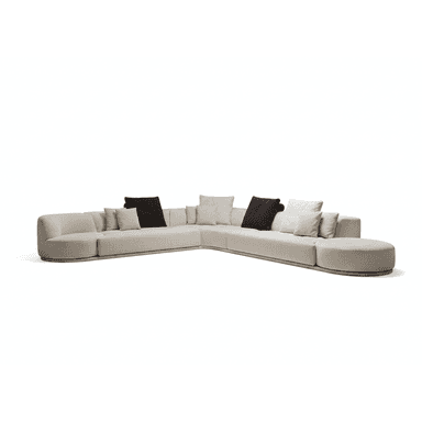 A large, contemporary low-profile curved modular sectional sofa, upholstered in a light beige woven fabric. It features multiple sections forming a sweeping L-shape, culminating in a round integrated ottoman. The sofa has soft, rounded edges and is supported by a subtle dark plinth base. Several accent throw pillows in varying shades of light cream and dark brown are arranged along the backrests. — 3D model (AI enhanced source)