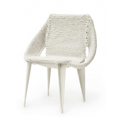 A modern armchair featuring a unique white chunky knitted textile covering the seat, backrest, and integrated armrests, supported by a minimalist white metal frame with four splayed legs. — 3D model (AI enhanced source)