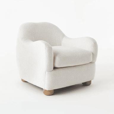 A contemporary armchair fully upholstered in a cream-colored bouclé fabric, featuring a soft, rounded silhouette. The chair has a deep seat with a removable cushion and gently curved armrests and backrest, all contributing to a plush and inviting appearance. It stands on four short, cylindrical, light-toned wooden legs. — 3D model (AI enhanced source)