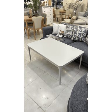 A modern rectangular coffee table featuring a light grey or off-white tabletop with softly rounded corners, supported by four subtly tapered legs matching the tabletop's color and finish. — 3D model (AI enhanced source)