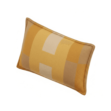 A rectangular decorative throw pillow featuring a geometric pattern composed of blocks of color in varying shades of yellow, beige, and light brown. The pillow has piped edges in a solid tan color, suggesting a finished, tailored look. The fabric appears to be a woven textile, possibly wool or a blend, with a visible texture. — 3D model (AI enhanced source)