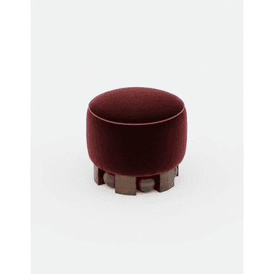 A round, upholstered ottoman with a deep red velvet fabric. The ottoman is characterized by a decorative piping along its top edge and a unique base constructed from dark wood elements, including carved spherical shapes and angular blocks arranged in a tiered pattern. The base provides a contrast to the soft upholstery of the seat. — 3D model (AI enhanced source)
