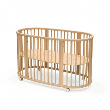 A natural wood, oval-shaped baby crib featuring vertical slats for safety and visibility, and small casters on the base for mobility. The mattress support is a slatted wooden panel. — 3D model (AI enhanced source)