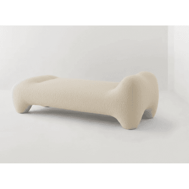 A long, low-profile, sculptural bench upholstered in a light, textured fabric, likely bouclé. It features organic, rounded forms with no hard edges, resembling an abstract bone or pebble shape. The design is minimalist yet impactful, intended as a statement piece. — 3D model (AI enhanced source)