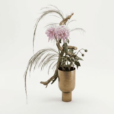 A sophisticated ikebana-inspired floral arrangement presented in a modern brass vase. The arrangement features large, pale pink chrysanthemums, delicate feathery dried grasses, and sprigs of eucalyptus with seed pods, all artfully interwoven with a natural driftwood branch. The vase itself is a cylindrical brass vessel with a tapering neck and a stout circular base, exhibiting a brushed or matte finish. — 3D model (AI enhanced source)