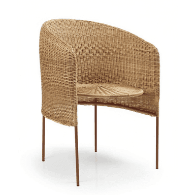 A contemporary barrel-shaped armchair featuring a natural woven rattan body and a minimalist metal leg structure. The chair has a rounded backrest that flows into integrated armrests, and a circular seat cushion is formed from the same woven material. The slender, tapered legs are made of metal with a reddish-brown finish, providing a modern contrast to the organic texture of the rattan. — 3D model (AI enhanced source)