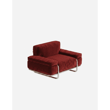 A single-seat armchair with a plush, deep red velvet upholstery. The armchair features a low-profile design with generously padded seat, back, and armrests. It is supported by a sleek, modern chrome metal frame that forms a cantilever base with rounded edges. The upholstery has a subtle tufted texture. — 3D model (AI enhanced source)